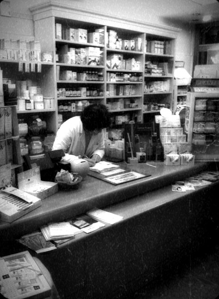 Bruna, che ha fondato Erba Amica nel 1997, al lavoro dietro al banco del negozio: fotografia d'archivio in bianco e nero