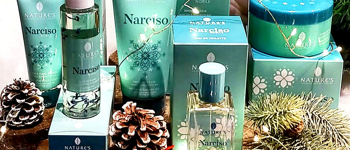 Composizione natalizia di prodotti da regalo su basi di legno, tra pigne e luci