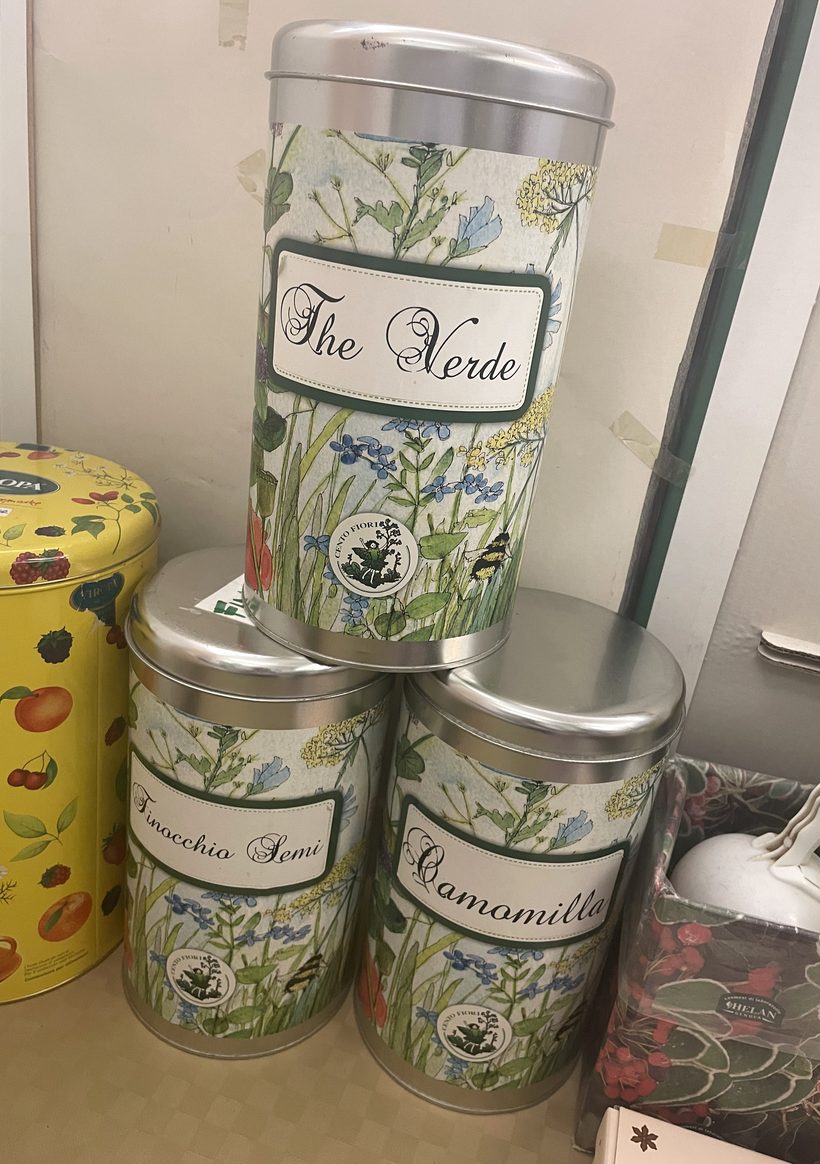 Latte illustrate di tè verde, camomilla e finocchio sullo scaffale di Erba Amica