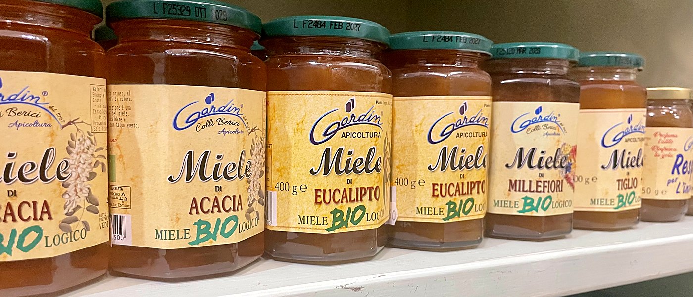 Vasetti di miele biologico di acacia, eucalipto, millefiori e tiglio allineati sullo scaffale
